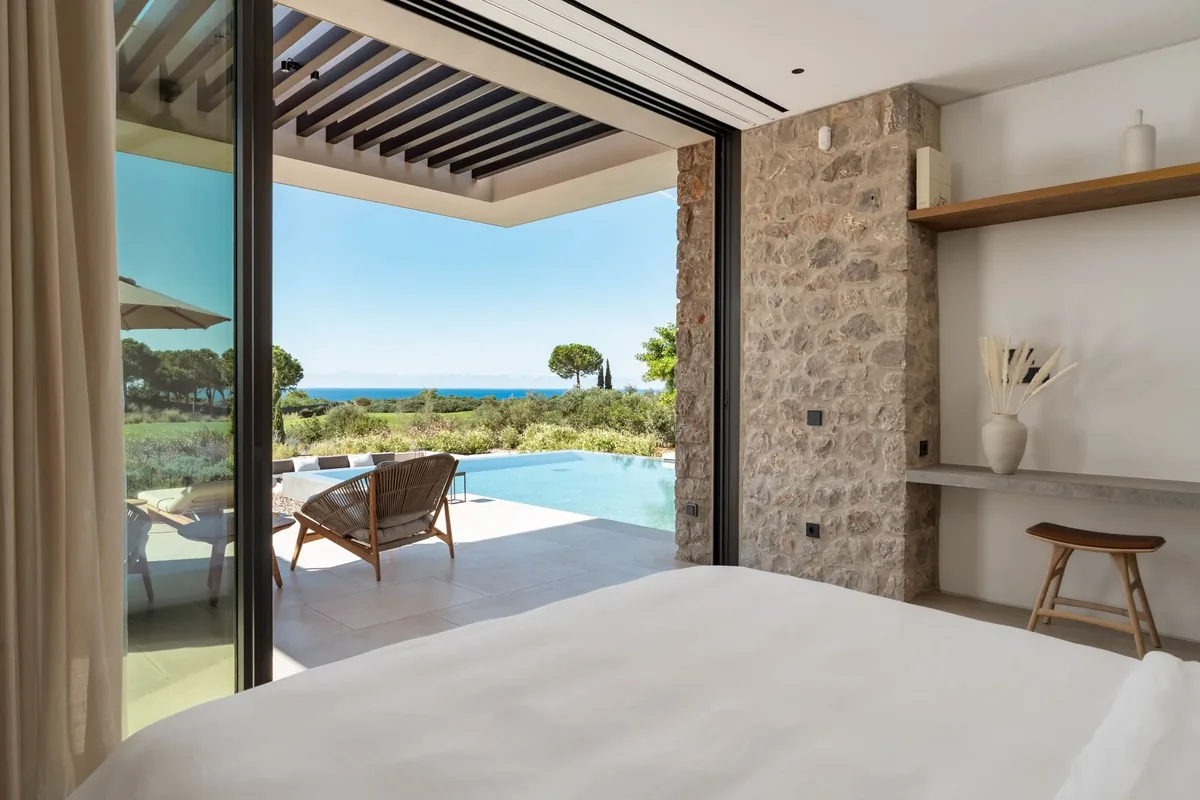 Bedroom looking through an open door towards the private pool